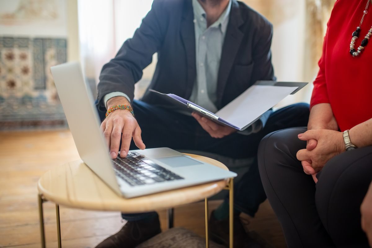 Advisor explaining documents to two clients in a meeting