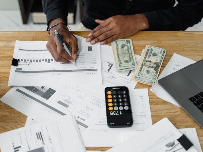 Accountant's desk with reports, calculator and laptop