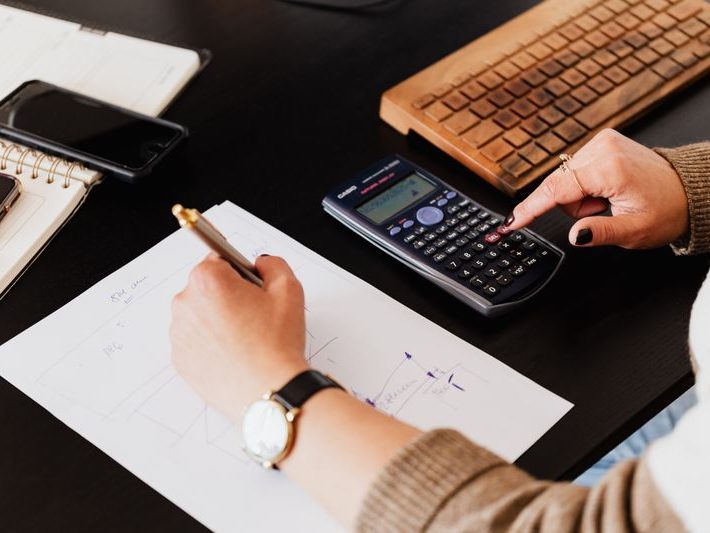 Hands with a calculator reviewing tax documents