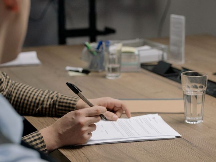 Person signing legal documents at a desk